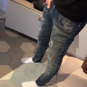 Blå jeans från Diesel - Säljer ett par snygga blå jeans från Diesel med en cool tvättad look. De har en klassisk femficksdesign och en bekväm passform. Perfekta för en avslappnad stil.