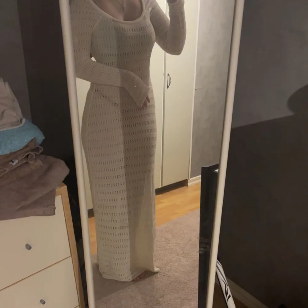 Säljer en elegant vit stickad långklänning med långärmad design. Klänningen har ett vackert hålmönster och en figurnära passform som framhäver silhuetten. Perfekt för sommarens varma dagar eller en stilfull kväll. Jag är 1,70 cm . Mekot.