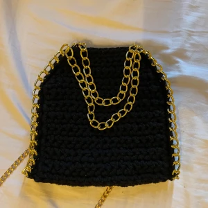 Stella McCartney liknande väska - Stella McCartney liknande handgjord, virkad, väska. Svart med guldkedja. Ingår både ett långt band och knapp inuti väska. Passar till alla tillfällen och rymmer mycket. Ca 18x20 cm💓💓