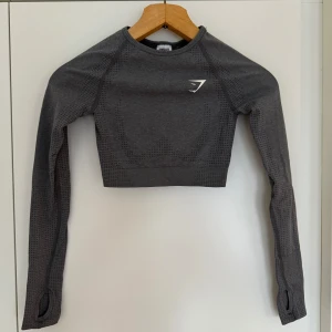 Träningsset från GymShark - Säljer detta superfina träningsset med en långärmad croppad topp och tights🩶 säljs då det är för litet för mig, använd ett par gånger.  Storlek XS, men passar även en XXS.
