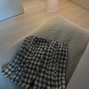 Rutig tubtopp med knappar - Snygg rutig tubtopp i svart och vit med guldknappar.