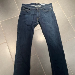 Mörkblå jeans från Replay - Snygga mörkblå jeans från Replay med klassisk femficksdesign och knappgylf. Perfekta för en stilren look. 