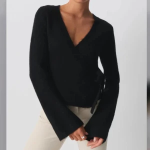 Svart omlottopp från Gina Tricot - Snygg svart omlottopp från Gina Tricot med v-ringning och knytning i sidan💗