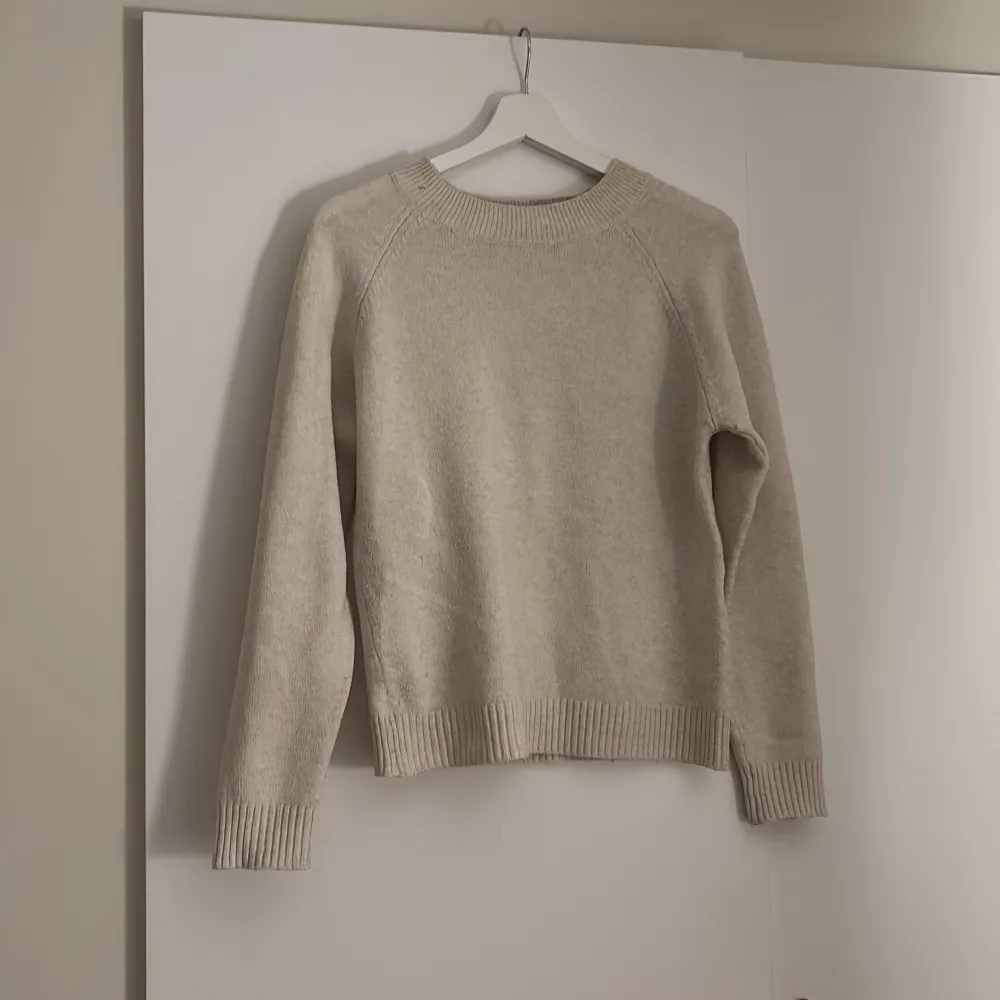 Säljer en mysig beige stickad tröja från Vero Moda. Tröjan har en klassisk design med långa ärmar och ribbade muddar vid ärmslut och nederkant. Perfekt för kyliga dagar!. Neuletakit & Villapaidat.