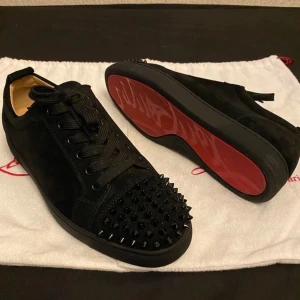 Christian Louboutin skor  - Snygga svarta sneakers i mocka med coola nitar på tån. Skorna har en klassisk snörning och en röd sula som ger en extra touch.  Storlek 43, kartong och dustbag, helt fräsch nyskick skor, skriv för mer frågor / bilder! 🙏 