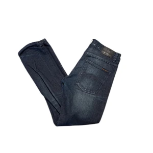 Mörkblå jeans från nudie - Snygga mörkblå jeans från nudie med en klassisk femficksdesign. Inte alls använda mycket skulle jag säga! Jeansen är av modellen grim Tim och jag säljer de då dom ej passar mig längre! Pris går att diskuteras mvh Matteus 