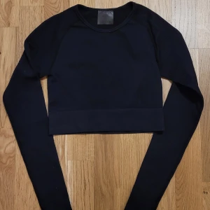 Svart träningstopp från Aim'n - Säljer en svart träningstopp från Aim'n i storlek XS. Tröjan har långa ärmar och en stilren design med en liten metallbricka med logotypen på baksidan. Perfekt för en sportig look eller avslappnad stil. Mycket skön i tyget och bra kvalité.