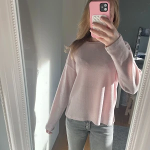 Ljusrosa tröja - Säljer en ljusrosa tröja med långa ärmar. Tröjan har en enkel och stilren design med en mjuk och bekväm passform. Perfekt för en avslappnad look.