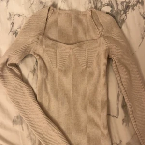 Beige ribbad tröja - Säljer en söt beige ribbad tröja med lång ärm och unik halsdesign💕Perfekt för att hålla sig varm och snygg under kyligare dagar❣️ tröjan har inga synliga defekter & är i toppskick!!💌