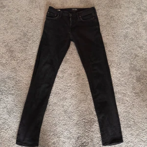 Svarta slim fit jeans 30/32 - Snygga svarta slim fit jeans med en klassisk design. De har en midwaist passform och är perfekta för en stilren look. Jeansen har fem fickor och en dragkedja med knappstängning. Nyskick då dem var för små för mig så bara testade en gång.