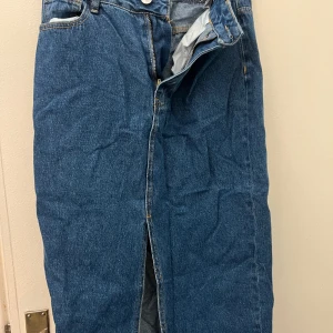 Blå jeanskjol med slits - Snygg blå jeanskjol med en stilren design och en slits framtill. Pris kan diskuteras 