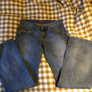 Blå lågmidjade bootcut jeans från Americanos - Säljer ett par supersnygga lågmidjade bootcut jeans med en ljus wash. Säljer eftersom de tyvärr är för små för mig. Midjemått: 37cm Innerbenslängd: 78cm Skriv gärna om ni har någon fråga!💞