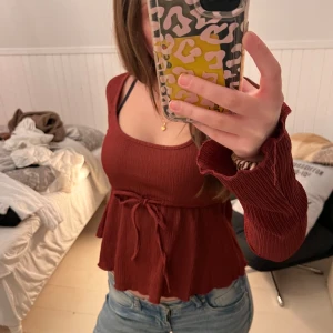 Röd ribbad topp med knytband från Nelly  - Säljer en jätte söt röd ribbad topp från Nelly. Använd fåtal gånger och har inga defekter. Skriv för fler bilder eller frågor