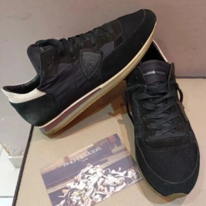 Svarta Philippe Model skor - Snygga svarta sneakers från Philippe Model med en stilren design. Skorna har snörning och en vit sula som ger en fin kontrast. Perfekta för en casual look.