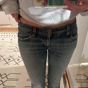 Blå jeans från Levis - Snygga blå jeans från Levis med en klassisk femficksdesign och låg midja. Jeansen har en straight passform och är tillverkade i denim med en lätt tvättad look. Perfekta för en avslappnad stil. Har sprättat upp längst ner. Säljer pga dem är för korta för mig köpt second hand. 