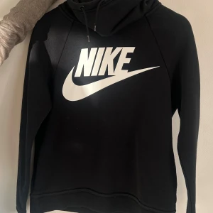Svart hoodie från Nike - Säljer en svart hoodie från Nike! Hoodien har en turtleneck och nike logo på framsidan. Säljer den då den inte passar längre!❤️ vid ytterligare frågor hör av er.