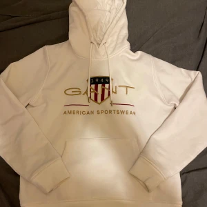 Vit hoodie från GANT - Säljer en stilren vit GANT hoodie som passar allt möjligt! Storlek M men passar S med. Dm mig om vad som helst om hoodien. Har en liten fläck på framsidan men de syns inte