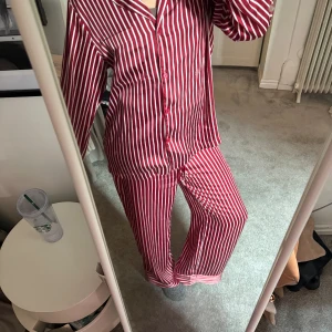 Röd randig pyjamas - Perfekt pyjamas till julen i satin. Båda delarna är i s