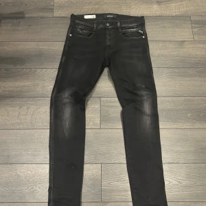 Svarta Anbass hyperflex Replay jeans - Snygga svarta jeans från Replay med en slim passform. Dom är i väldigt bra skick 9/10. Dom har storleken W31,L32.