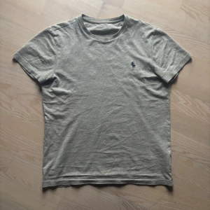 Ralph Lauren T-Shirt - En skön grå tischa ifrån polo ralph lauren som säljes så jag växt ur den. Storlek är XS och passar bra mellan ca 155-170! Nypris på denna tröja ligger runt 600-700 kronor vilket gör detta till en prisvärd deal! Om ni har frågor eller funderingar är det bara att höra av sig!