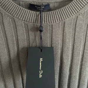 Olivefärgad ribbad tröja från Massimo Dutti - Säljer sprillans ny stilren olivefärgad tröja från Massimo Dutti. Tröjan är ribbad och har långa ärmar med en klassisk rund halsringning. Perfekt för en elegant och avslappnad look.