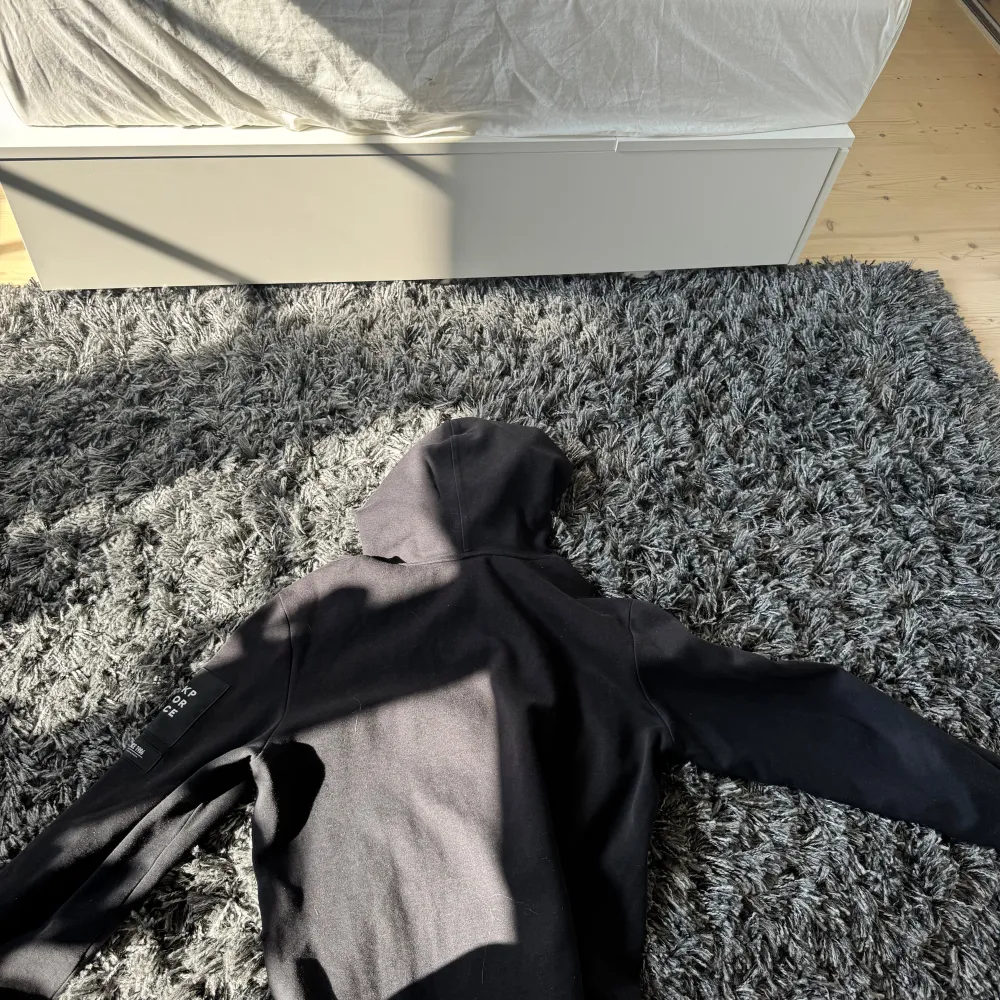 Säljer en stilren svart hoodie från Peak Performance. Den har en klassisk design med en stor ficka framtill och en bekväm huva. Perfekt för en avslappnad look.. Neuletakit & Villapaidat.