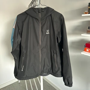 Svart vindjacka från Haglöfs - Säljer en svart vindjacka från Haglöfs, strl L men passar även bra som strl M. Finns en mindre skrapa vid ena fickan men inte så synlig. Pris går att diskutera! Org pris 3000kr