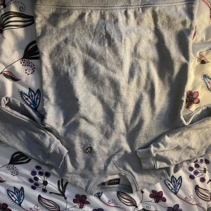 Grå tröja från Lyle & Scott/ Svart tröja från Calvin Klein  - Säljer en stilren grå tröja från Lyle & Scott. Tröjan har en liten broderad logotyp på framsidan och är tillverkad i ett mjukt material. Perfekt för en avslappnad look, .                                  Jag säljer även en tröja som är från Calvin Klein, som är strl M men passar även S. 