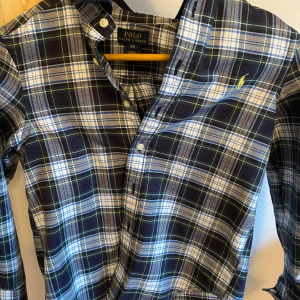 Rutig skjorta från Ralph Lauren - Säljer nu denna väldigt snygga Ralph lauren skjortan, då den inte kommer till användning längre. Den är perfekt skick (9/10) och inga defekter. Den är o storlek S (barnstorlek), och skulle tippa på att den passar någon som är runt 140-146, beroende på hur man vill att den ska sitta. Hör jätte gärna av er vid frågor och funderingar, om mått osv!👍🏻