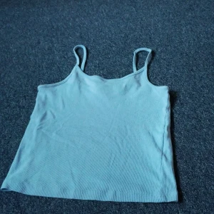 Ljusblå ribbad linnetopp FB Sister - Ljusblå ribbad linnetopp från FB Sister i storlek S. Toppen har smala axelband och ärmlös design, perfekt för varma dagar. Materialet är mjukt och stretchigt, vilket gör den skön att bära. Enkel och stilren modell som är lätt att matcha med jeans eller kjol. Kan tvättas innan jag skickar det om du vill😄