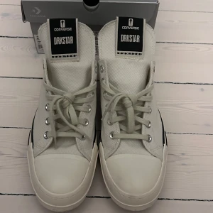 Converse X Rickowens  DRKSHDW  vita sneakers - Säljer ett par Converse Drksshdw  sneakers i vitt canvas med chunky vit sula och svarta detaljer. Skorna har rund tå, snörning och coola råa kanter på plösen. Perfekta för dig som gillar streetstyle och vill sticka ut med en unik twist på klassiska Converse.