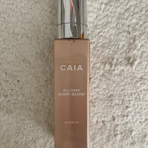 CAIA All Over Body Glow Golden Tan - Säljer CAIA All Over Body Glow i färgen Golden Tan. Ger huden en snygg solkysst lyster med skimrande finish. 