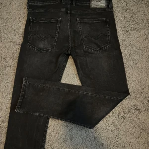 Replay Grover svarta jeans straight fit - Svarta Replay Grover jeans i straight fit med klassisk femficksdesign och snygga detaljer på bakfickorna. Är runt 1,80 och de passar perfekt! 