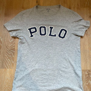 Grå t-shirt Polo Ralph Lauren  - Grå t-shirt från Polo Ralph Lauren i storlek S. Tröjan har ett pyttelitet hål i armen som knappt syns. Skriv vid minsta fundering! Priset är ej hugget i sten!