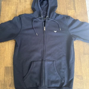 Armani Hoodie - En otroligt stilren zip hoodie från Armani som är i princip nyskick. Endast använd ett fåtal gånger. Tveka inte på att höra av dig om du har några frågor eller funderingar! 