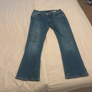 Blå bootcut jeans från LTB - Snygga blå jeans från LTB med bootcut passform. Klassisk femficksmodell med dragkedja och knapp framtill. Jeansen har en lätt tvättad look och är tillverkade i mjukt denimtyg som sitter skönt hela dagen. 