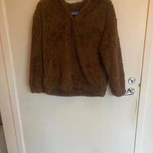 Brun fluffig fleece tröja - Mysig brun fleece tröja från Shein med lång ärm och loose passform. Tröjan har en fluffig yta som känns supermjuk och är perfekt för kalla dagar. Med en kort krage vid halsen med rundad hals och avslappnad stil.