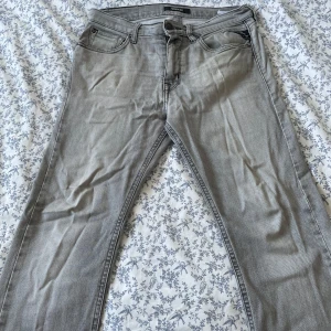 Replay grå jeans slim fit - Priset är diskuterbart!                   Snygga grå jeans från Replay med klassisk femficksdesign och raka ben. Jeansen har svarta kontrastsömmar på bakfickorna och Replay-logga på linningen. Materialet är mjukt jeans-tyg som sitter skönt och passar till många olika stilar.