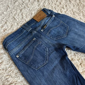Vintage Lady Lee Rider jeans - Vintage super lågmidjade bootcut jeans från Lee. 😍 Perfekt skick, förutom att de är uppsydda vilket inte syns. (se bild) 🫶🏻 Mått på bilder, men kan fixa fler i DMs! Storlek: W26, L33. Jag får inte på mig jeansen längre, så jag kan inte visa hur dem ser ut på. Kan försöka leta upp bilder. ❤️Fler jeans finns på min profil! 