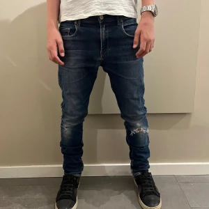 Replay Anbass slim fit blå - Säljer ett par Replay Anbass jeans i mörkblå tvätt med slitningar vid knäet och snygga detaljer på bakfickorna. Modellen är slim fit med. Jeansen är gjorda i stretchig bomull för skön passform. Och är gjorda för stil 😉😉