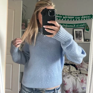 Ljusblå stickad tröja med loose fit - Mysig ljusblå stickad tröja med loose fit och breda ribbade muddar vid ärmslut och nederkant. Tröjan har rund hals och långa ärmar, perfekt för att ge en chill vibe till din outfit. Passar grymt med jeans eller kjol för en avslappnad look. säljer för den ej kommer till användning.❤️köpt för 600