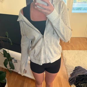 Grå hoodie från Abercrombie & Fitch - Säljer en ljusgrå hoodie från Abercrombie & Fitch med dragkedja och huva. Tröjan är perfekt nu till skolan🩷