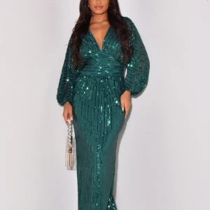 Grön glittrig långklänning med v-ringning - Säljer en magisk grön långklänning med glittriga paljetter och djup v-ringning. Klänningen har långa puffärmar och markerad midja som ger en snygg siluett. Perfekt för att sticka ut på bal eller fest! Materialet är syntet och klänningen har ett glittrigt mönster. Använd en gång!!!                                                                   
