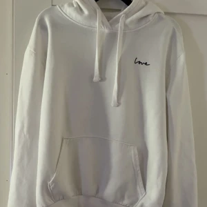 Vit hoodie från H&M - Jättefin vit hoodie från H&M Divided i storlek M. Tröjan har en broderad svart text 'love' på bröstet. Använd ett fåtal gånger💕skriv för fler bilder eller andra frågor!!!(pris kan alltid diskuteras)💕