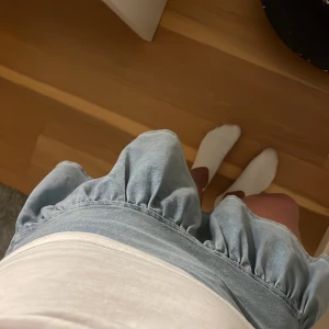 Ljusblå volangkjol i jeans från H&M - Supersöt ljusblå kort jeanskjol från H&M med volangkant och lätt utsvängd passform. Kjolen har en mjuk denimkänsla och är perfekt för dig som gillar en chill och trendig stil. Enkel att matcha med både t-shirt och hoodie. Passar mig som vanligt vis har xs.