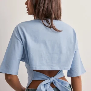 Blåa tröja med knyt i ryggen - Superfin tröja som ej kommer till användning då jag har den svarta, fin ljusblå färg. Finns ej att köpa på hemsidan längre. Fint skick inga defekter