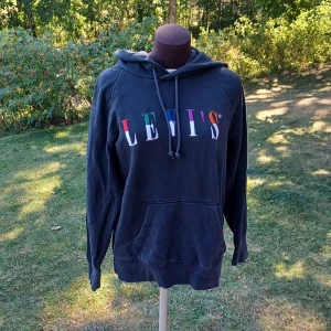 Hoodie med färgglad logga - Säljer en svart hoodie från Levi's med stor färgglad logga på bröstet. Tröjan har huva och en ficka framtill💙🪁💤Välanvänd men fortfarande i fint skick. Det är bara att skriva om man har frågor!😊💖