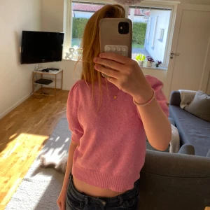 Rosa stickad tröja Vero Moda XS - Säljer en söt rosa stickad tröja från Vero Moda i storlek XS. Tröjan har puffiga korta ärmar och ribbad kant vid midjan och halsen. Perfekt för dig som gillar en feminin och trendig look. Materialet är mjukt och skönt mot huden.
