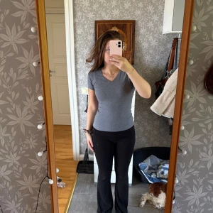 Grå v-ringad topp  - Säljer en enkel och snygg grå v-ringad topp från Cubus i ekologisk bomull. Modellen har korta ärmar, perfekt för dig som gillar en clean och stilren look. Passar dig som vill ha en basic topp med skön passform.