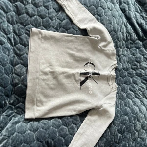 Ljusgrå sweatshirt från Calvin Klein Jeans - Säljer en stilren ljusgrå sweatshirt från Calvin Klein Jeans i storlek XS. Tröjan har ett stort CK-logotryck på bröstet, rund hals och långa ärmar. Tillverkad i mjuk 100% bomull för skön komfort. Perfekt för dig som gillar cleana och klassiska streetlooks. Inga defekter!